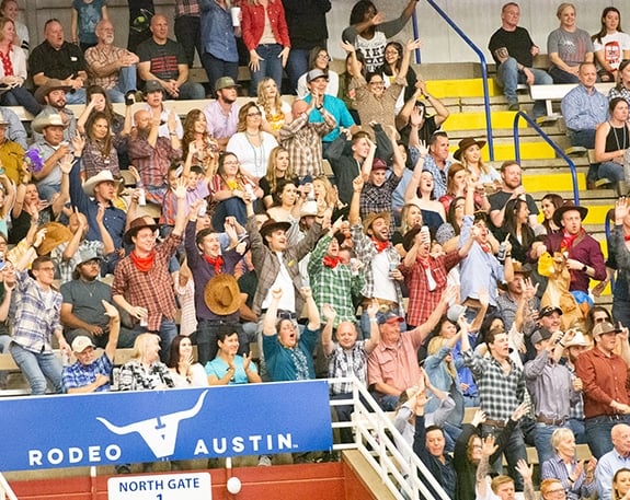 fans cheering in the rodeo arena