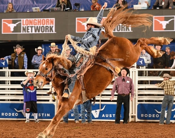 Rodeo Austin contestant riding bucking horse