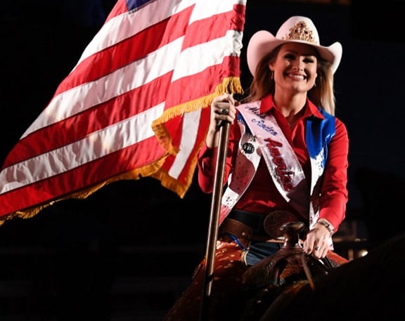 rodeo queen riding horse with American flag