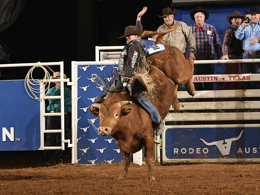Rodeo contestant rides a bull for eight second at Rodeo Austin